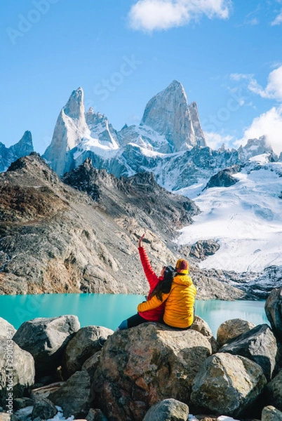 Fototapeta Couple in love on Mount Fitzroy, Patagonia trek. Scenic view of snowcapped mountain tops. Blue sky, turquoise lake and scenic rock landscape. Shot in Argentina. Nature, travel, adventure, hiking.