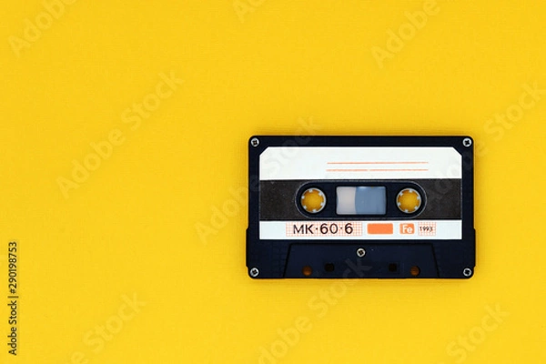 Obraz Old audio tape cassette on a bright yellow background. Top view, old technology concept
