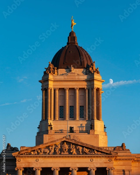 Obraz Closeup of the Manitoba Legislative Building with the "Golden Boy" statue on top, shot during golden hour. (Moon visible in the background) - Winnipeg, Manitoba/Canada