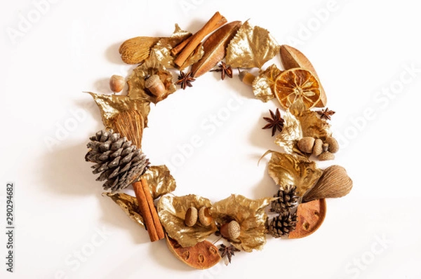 Obraz Autumn Winter composition. Wreath made of leaves, cone, cinnamon, cotton and acorns on white background