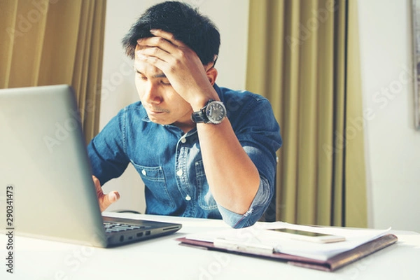 Fototapeta Worried stressed businessman shocked by bad news using laptop at work, desperate bankrupt investor lost money online depressed by financial problem debt, frustrated worker tired of overwork.