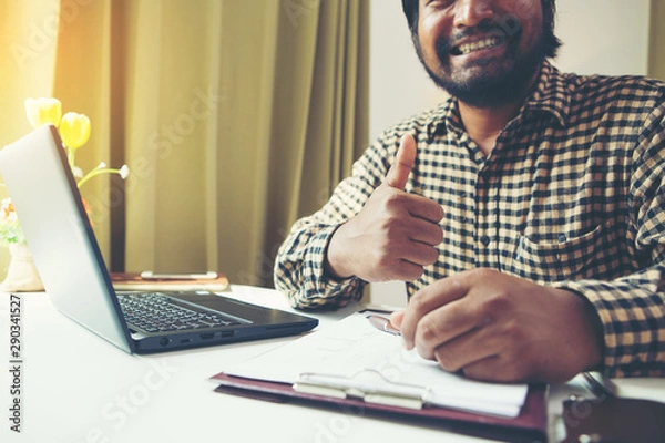 Fototapeta Businessman showing thumbs up in his workplace.Tump up concept.