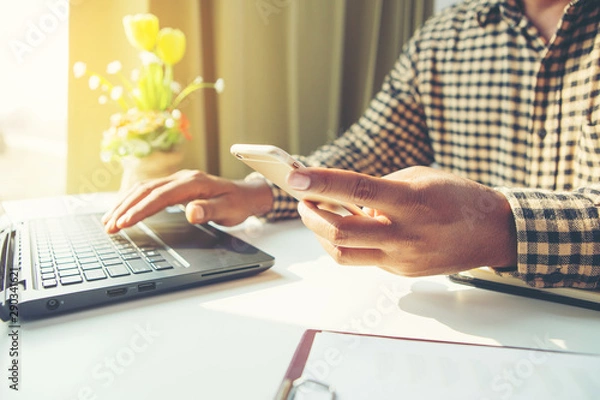 Fototapeta Side view shot of a man's hands using smart phone in interior.