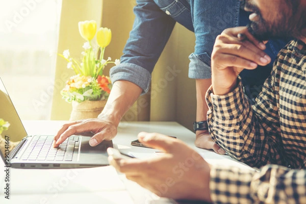 Fototapeta Business meeting time. Photo young account managers crew working with new startup project. Notebook on white table. Idea presentation, analyze plans.