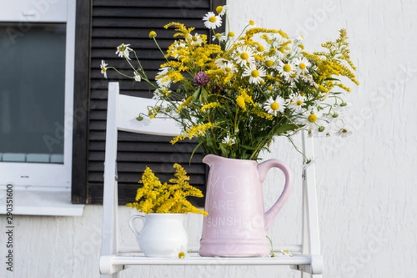 Fototapeta Bouquet in jar on background of house white wall