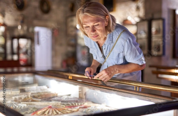 Fototapeta Woman visitor in the historical museum looking at art object.