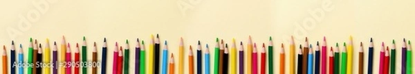 Fototapeta Multicolored wooden pencils for school on yellow paper background. School and office stationery on yellow background. Concept back to school. Banner with copy space.