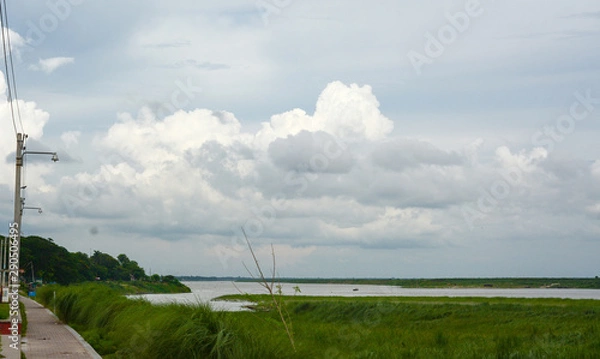 Fototapeta Beautiful Cloudscape with Clouds beside the river and walkways for people