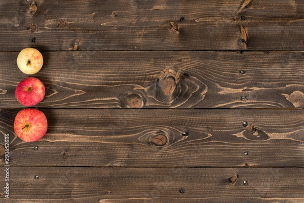Fototapeta Three apples on a wooden rustic table top view