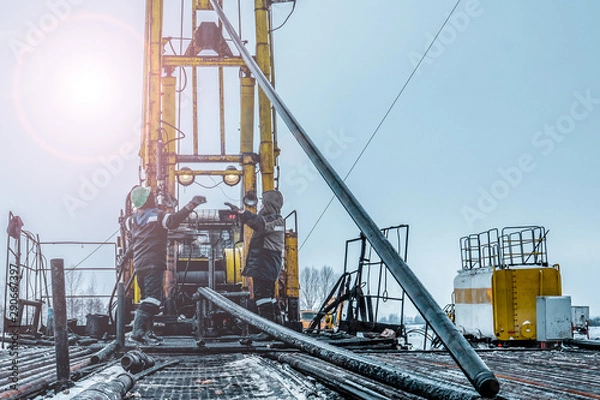 Fototapeta Offshore oil rig worker prepare tool and equipment for perforation oil and gas well at wellhead platform. Making up a drill pipe connection. A view for drill pipe connection from between the stands