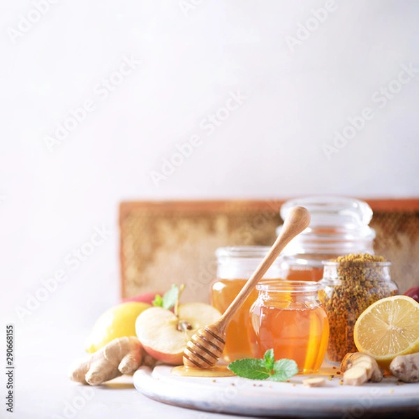 Fototapeta Alternative medicine concept. Ingredients for flu fighting natural hot drink. Copy space. Lemon, ginger, mint, honey, apple and spices on grey background