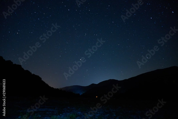 Fototapeta Stars in the night sky overhead. Night starry sky over the mountains. Stars and constellations in the sky.