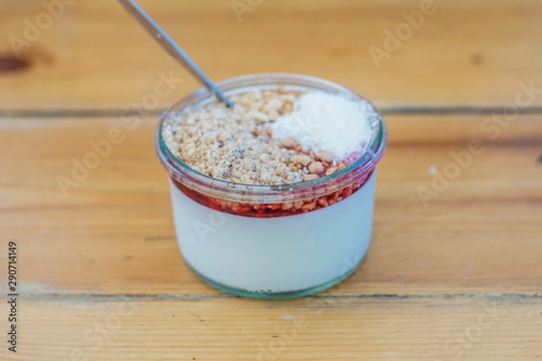 Fototapeta   "Malabi" on a wooden table - "Malabi" is  the Israeli ultimate dessert ! milk pudding that served with rose water and sugar syrup , nuts and grounded coconut. 