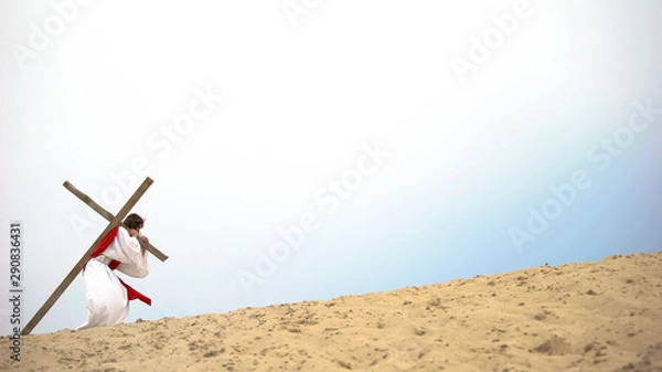 Fototapeta Jesus with heavy wooden cross hardly walking, biblical story of crucifixion