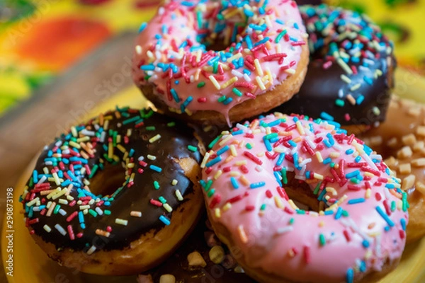 Fototapeta  donuts, close-up photo with selective focus - assorted donuts with chocolate frosted, pink glazed and sugary sprinkles. 