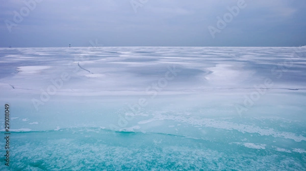 Fototapeta Colorful frozen lake surface during a heavy overcast day