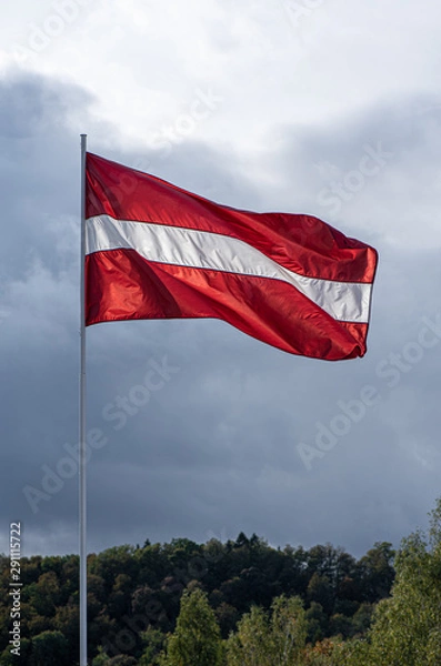 Obraz Latvian flag on the mast waving on the wind in the blue sky