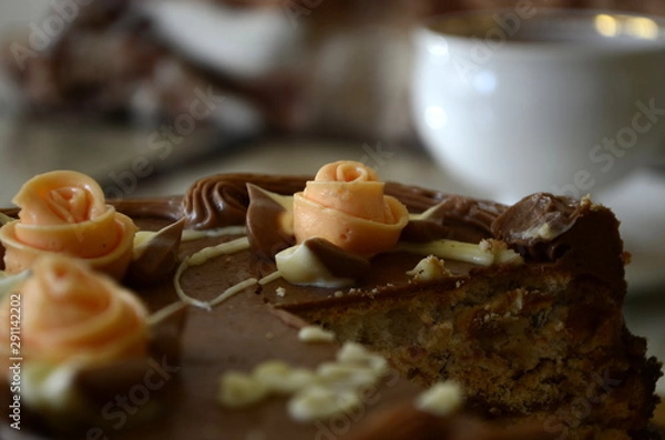 Fototapeta Cake with nuts and meringues decorated with cream rose. Shallow depth of field, close-up.