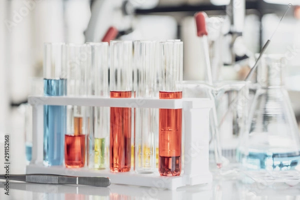 Fototapeta Team of Medical Research Scientist Conducts Experiments in Laboratory with Microscope, Test Tubes, Micropipette and other equipment.