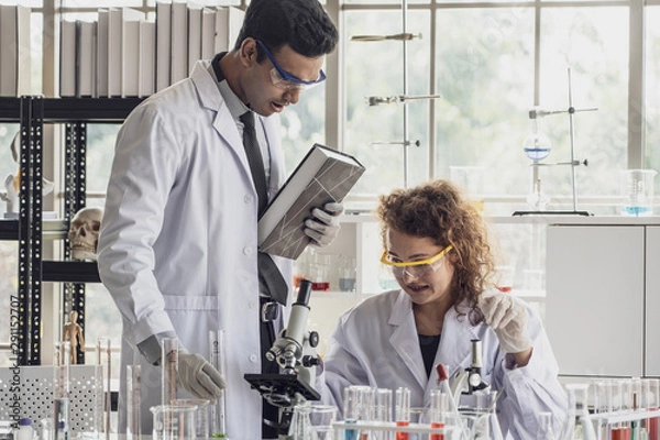 Fototapeta Team of Medical Research Scientist Conducts Experiments in Laboratory with Microscope, Test Tubes, Micropipette and other equipment.