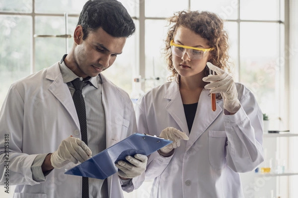 Fototapeta Team of Medical Research Scientist Conducts Experiments in Laboratory with Microscope, Test Tubes, Micropipette and other equipment.