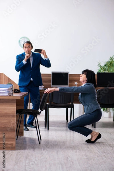 Fototapeta Two employees doing sport exercises in the office