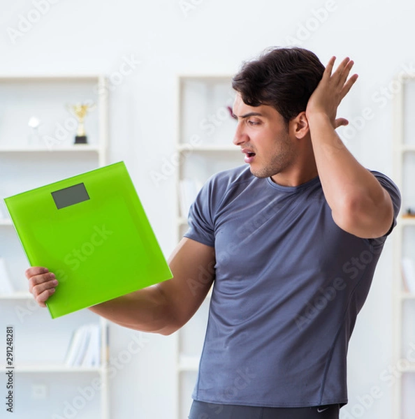 Fototapeta Man with scales in sports and health concept