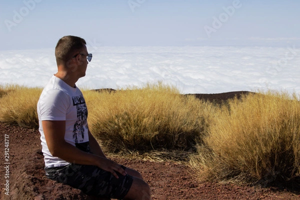 Obraz young man above the clouds