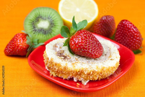 Fototapeta cake,kiwi,lemon and strawberries lying on the orange fabric