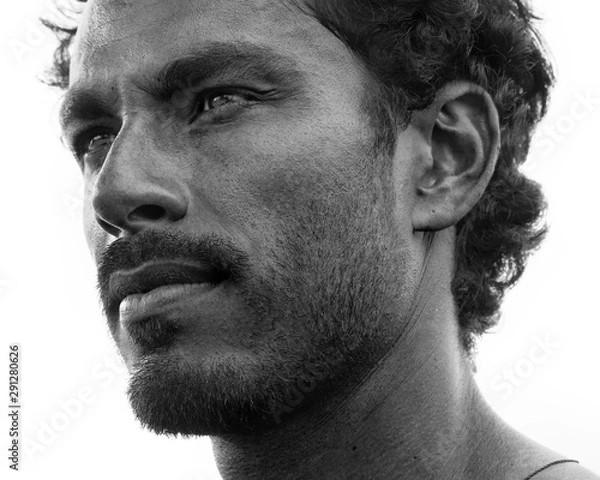 Fototapeta Bliska portret zdrowego mężczyzny o czarnych włosach, silnych rysach, patrząc prosto przed siebie pod kątem trzech czwartych, czarno-biały