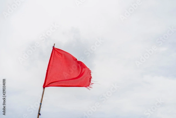 Fototapeta Red flag warning flags wind blue sky