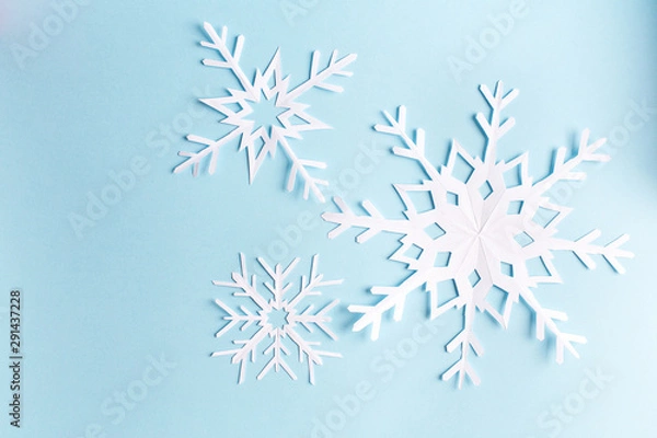 Obraz blue background with paper snowflake, top view
