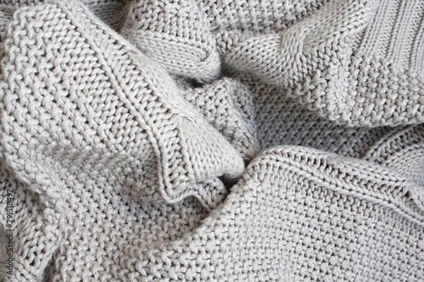 Fototapeta Crumpled beige knitted blanket or plaid. The knitted fabric was soft and warm, wrinkled. Texture for background.