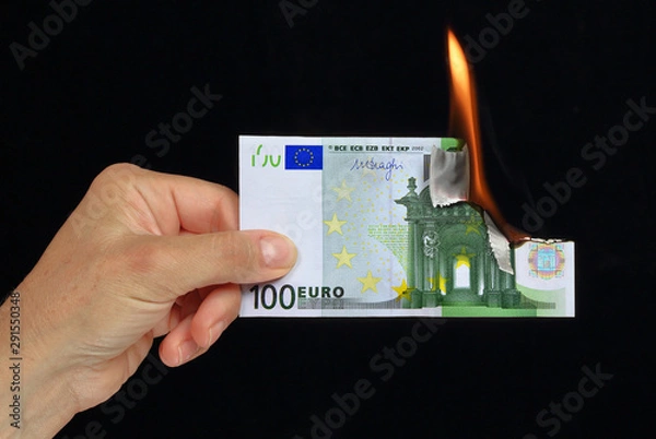 Fototapeta hand holding a burning european currency bank note