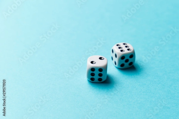 Obraz White gaming dice on blue background. Top view. Flat lay. Copy space. Game of chance concept. Close-up. Pastel colors