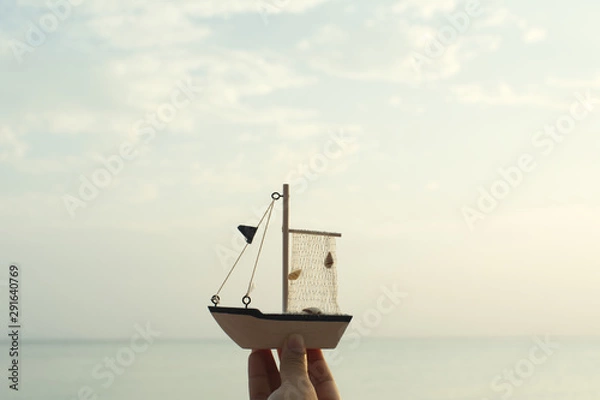 Obraz Hand holding model boat and the sea background.