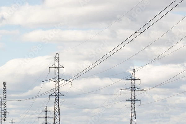 Fototapeta High-voltage technological power lines on metal poles with powerful power wires against the sky