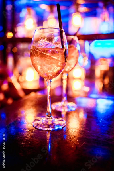 Fototapeta red dice in the cocktail glass in front of lounge bar