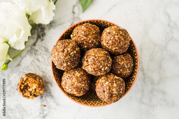 Fototapeta Energy protein balls with healthy ingredients on marble table. Home made with dates, peanut butter, flax and chia seeds, oats, almond and chocolate drops