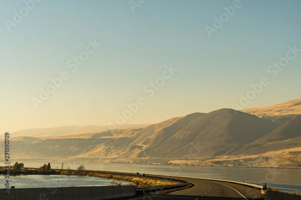 Fototapeta The US-30 highway passing by the Columbia River with water on both sides of the road near The Dalles