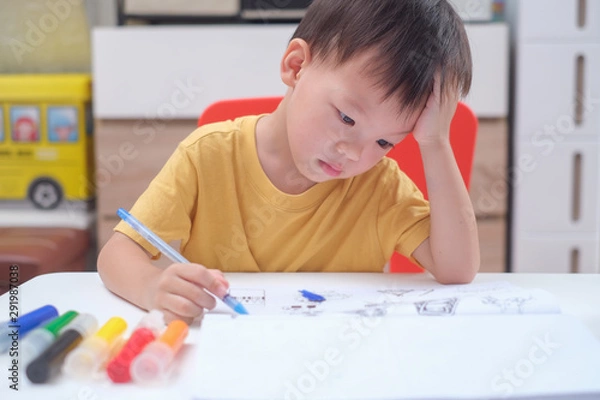 Fototapeta Cute Asian 3 - 4 years old toddler boy child writing / drawing with pencil, Student doing homework, Little kid prepare for kindergarten test, Creative play for toddler, improve focus in child concept