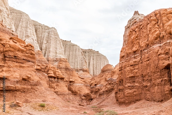 Fototapeta White and red layers of hoodoo sandstone rock formations view in campground in desert landscape in Goblin Valley State Park