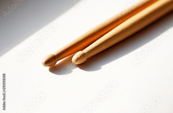 Fototapeta two drumsticks lie in the window sill with sunlight through windows
