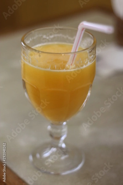 Fototapeta Glass of orange juice on wooden table