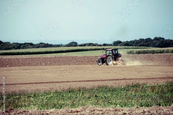 Fototapeta nice view of a farmer plowing his fields