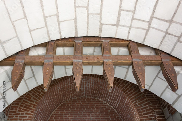 Obraz An ancient gateway made of stonework, wood and metal. Rusty and weathered.