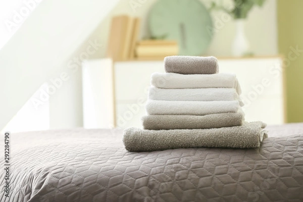 Fototapeta Stack of clean towels on bed