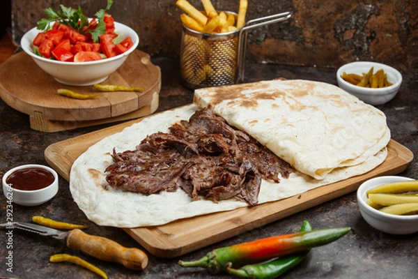 Fototapeta Lamb steak doner in flatbread served with fresh tomato and cucumber salad
