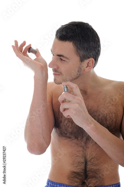 Fototapeta handsome young male spray perfume on his skin. isolated on white