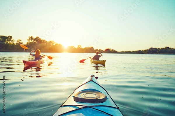 Fototapeta People kayak during sunset in the background. Have fun in your free time.
